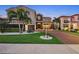 Elegant two-story home featuring lush landscaping, a brick driveway, and a classic Mediterranean-style tile roof at 10196 Bucklow Hill Dr, Orlando, FL 32832