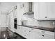 Kitchen features white cabinetry, stainless appliances, a stone backsplash and black hardware at 10196 Bucklow Hill Dr, Orlando, FL 32832