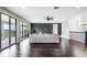 Open-concept living room features hardwood floors, dark accent wall, and glass doors that leads to covered outdoor patio at 10196 Bucklow Hill Dr, Orlando, FL 32832