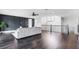 Spacious open-concept living room with hardwood floors, dark accent wall, chandelier, and staircase with black wrought iron at 10196 Bucklow Hill Dr, Orlando, FL 32832