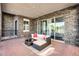 Covered patio with stone walls, brick flooring, and comfortable outdoor seating at 10196 Bucklow Hill Dr, Orlando, FL 32832