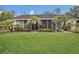 Lush green backyard with tropical palms and screened-in patio at 10528 Old Dade City Rd, Lakeland, FL 33810