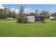 Beautiful backyard showcasing a large grassy area, mature trees, and garden shed at 10528 Old Dade City Rd, Lakeland, FL 33810