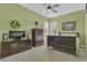 This bedroom features neutral carpet, green walls and a ceiling fan at 10528 Old Dade City Rd, Lakeland, FL 33810