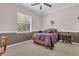 Bedroom with neutral walls and carpet and a bed covered with a purple quilt at 10528 Old Dade City Rd, Lakeland, FL 33810