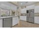 Bright kitchen features stainless steel appliances, tiled flooring, and white cabinets with bright natural lighting at 10528 Old Dade City Rd, Lakeland, FL 33810