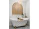 Inviting bathroom with free standing tub, gold fixtures, arched wood accent and a modern tile floor at 1113 Black Acre Trl, Winter Springs, FL 32708