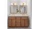 Elegant bathroom with double vanity, granite countertops, gold framed mirrors and modern tile flooring at 1113 Black Acre Trl, Winter Springs, FL 32708