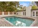 A captivating in-ground pool reflecting the sky, complete with brick trim and a modern-style privacy fence at 1113 Black Acre Trl, Winter Springs, FL 32708