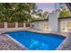 A picturesque pool illuminated at twilight, surrounded by lush trees and a white textured chimney at 1113 Black Acre Trl, Winter Springs, FL 32708