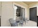 Relaxing outdoor balcony space with sliding glass doors, chairs, and a small table, great for enjoying fresh air at 114 Vista Verdi Cir # 136, Lake Mary, FL 32746