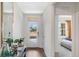 Bright hallway with hardwood floors, with a front door in view and access to the main bedroom at 1196 Alstonia Ln, Mount Dora, FL 32757