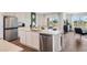 Modern kitchen with a large island, stainless steel appliances, and stylish white cabinetry at 1196 Alstonia Ln, Mount Dora, FL 32757