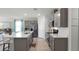 Stylish kitchen featuring a large island with seating, stainless steel appliances, and sleek gray cabinets at 1200 Alstonia Ln, Mount Dora, FL 32757