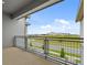 Balcony with metal railing and a neighborhood view of local road, green space and large building in the background at 14259 Kellogg Ave, Orlando, FL 32827