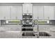 Close up shot of a kitchen with modern appliances, granite countertops and gray subway tile at 14259 Kellogg Ave, Orlando, FL 32827