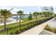 Park view of playground on artificial lake, black fencing, picnic tables, palm trees, and sidewalk at 14259 Kellogg Ave, Orlando, FL 32827