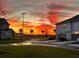 View of a street between two modern homes at sunset after a light rain at 14259 Kellogg Ave, Orlando, FL 32827