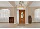Welcoming foyer featuring a decorative front door, neutral color palette, and tile flooring at 1585 Maidencane Loop, Oviedo, FL 32765