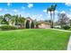 Charming single-story tan home boasts a lush green lawn and well-maintained landscaping at 1585 Maidencane Loop, Oviedo, FL 32765
