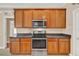 Kitchen showcasing wood cabinets, stainless steel appliances, and granite counters at 1585 Maidencane Loop, Oviedo, FL 32765