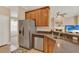 Kitchen featuring stainless steel refrigerator, sink, dishwasher, and wood cabinets at 1585 Maidencane Loop, Oviedo, FL 32765