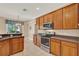 Bright kitchen features stainless steel appliances, wood cabinets, and granite countertops at 1585 Maidencane Loop, Oviedo, FL 32765