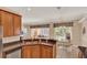Spacious kitchen featuring wood cabinets, granite countertop and view into the dining area and pool at 1585 Maidencane Loop, Oviedo, FL 32765