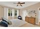 Main bedroom featuring a king bed, dresser, ceiling fan, and windows with white curtains at 1585 Maidencane Loop, Oviedo, FL 32765