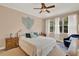 A calm main bedroom features a king bed, white curtains, ceiling fan, and neutral walls at 1585 Maidencane Loop, Oviedo, FL 32765