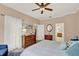 Main bedroom with king bed, dresser, white curtains, ceiling fan, and adjoining bathroom view at 1585 Maidencane Loop, Oviedo, FL 32765