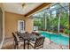 Screened pool area with dining table and chairs and tropical landscaped beds at 1585 Maidencane Loop, Oviedo, FL 32765