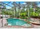 A beautiful, screened-in pool and spa surrounded by lush, tropical landscaping at 1585 Maidencane Loop, Oviedo, FL 32765