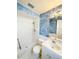 Bathroom featuring a white tile shower, and white sink with artistic blue accent wall at 1603 Gaston Foster Rd, Orlando, FL 32812