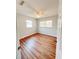 Cozy bedroom with hardwood floors, two windows and a ceiling fan at 1603 Gaston Foster Rd, Orlando, FL 32812