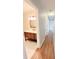 Hallway view leading to bathroom with wood vanity and marble flooring at 1603 Gaston Foster Rd, Orlando, FL 32812