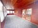 Enclosed sunroom featuring wood paneling, carpeted floors, and french doors at 1603 Gaston Foster Rd, Orlando, FL 32812