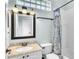 Bathroom featuring a vanity with granite countertop, framed mirror and tub-shower with decorative shower curtain at 1610 River Birch Ave, Oviedo, FL 32765