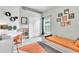 Bedroom boasts modern decor, unique lighting, and a playful orange accent color at 1610 River Birch Ave, Oviedo, FL 32765