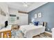 Bright bedroom with blue accent wall, white comforter, and desk area with window views at 1610 River Birch Ave, Oviedo, FL 32765