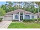 Charming single-Gathering home with lush green lawn, an attached garage, and manicured landscaping at 1610 River Birch Ave, Oviedo, FL 32765