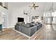 Bright living room featuring a large gray sofa and tile floors leading to the entryway at 1610 River Birch Ave, Oviedo, FL 32765