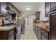 Galley kitchen featuring stainless steel appliances, dark wood cabinets, and tile backsplash at 1828 Matterhorn Dr, Orlando, FL 32818