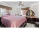 Bedroom with ceiling fan, pink bedspread, tile flooring and a large dresser with an oval mirror at 1828 Matterhorn Dr, Orlando, FL 32818
