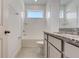 Bright bathroom with granite countertops, white cabinets, and a tiled bathtub at 18964 Rawson St, Orlando, FL 32827
