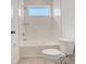 Bright bathroom showcasing a white tiled shower-tub, complemented by a window bringing in natural light at 18964 Rawson St, Orlando, FL 32827