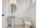 This bathroom has a pedestal sink, toilet, and tiled floors at 18964 Rawson St, Orlando, FL 32827