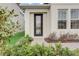 Charming front entrance featuring a modern door, lush landscaping, and a welcoming walkway to the home at 18964 Rawson St, Orlando, FL 32827