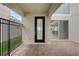 Charming covered porch featuring an elegant door, brick flooring, and a view of the manicured backyard at 18964 Rawson St, Orlando, FL 32827