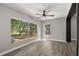 A bright bedroom featuring hardwood floors, a ceiling fan, and large windows offering ample natural light at 2014 10Th Nw St, Winter Haven, FL 33881